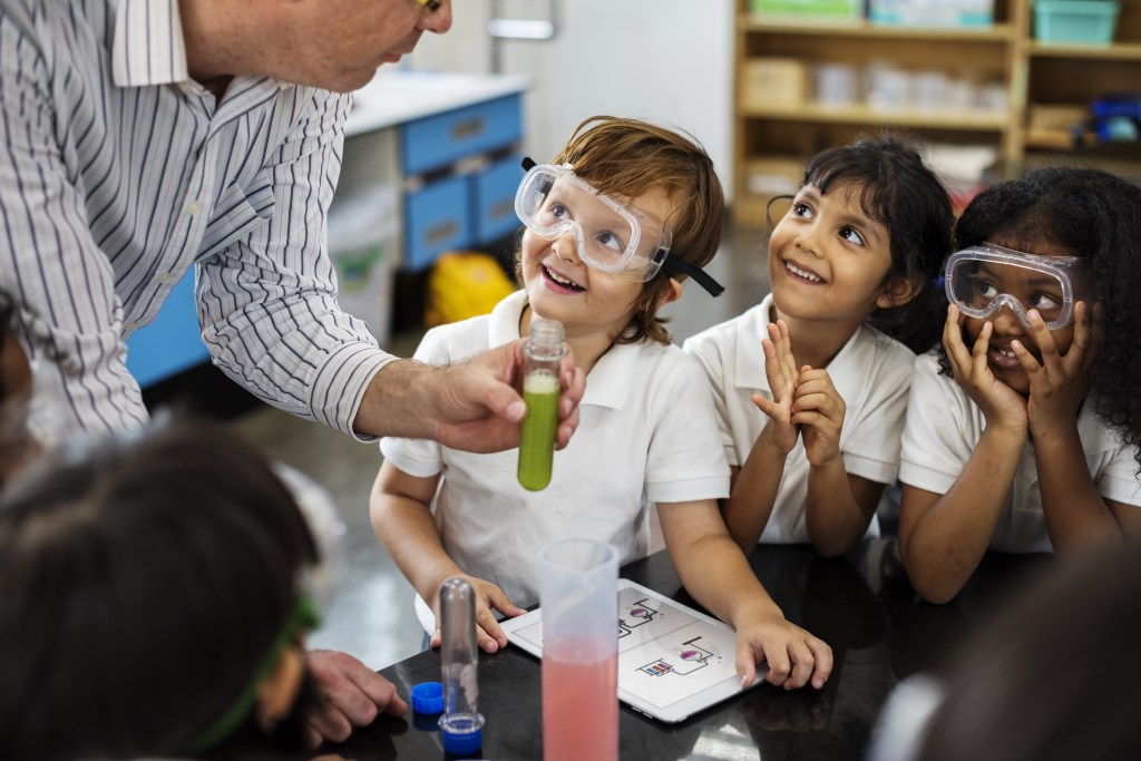 Teachers demonstrating experiment with primary aged students